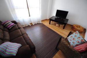 ein Wohnzimmer mit einem Sofa und einem TV in der Unterkunft Quinta Cale Breo. Vivenda Turística Rural 