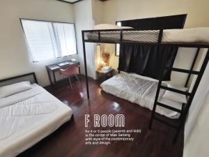 Zimmer mit 2 Etagenbetten und einem Schreibtisch in der Unterkunft ATOM Poshtel in Mae Sariang