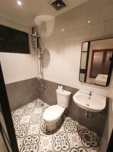 a bathroom with a toilet and a sink at The Hub District Garden Suites in Manila