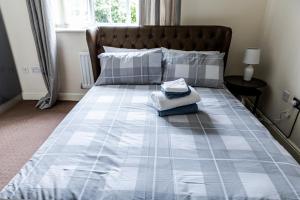 1 cama azul y blanca con cabecero marrón y almohadas en Resource Homes, en Bradshaw