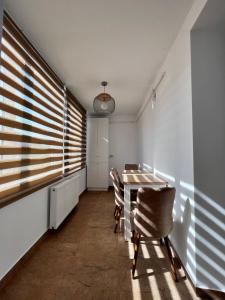 d'une salle à manger avec une table, des chaises et une fenêtre. dans l'établissement Ancodirect Apartments, à Rădăuţi