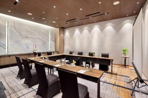 a conference room with a long table and chairs at Hotel Aruss Semarang in Semarang
