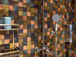 a shower in a bathroom with colorful tiles at Vinica Castle in Vinica