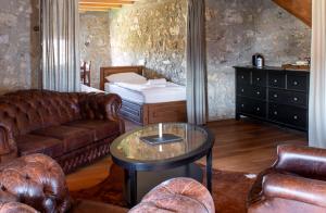 Vinica Castle في Vinica: غرفة معيشة مع أريكة وطاولة وسرير