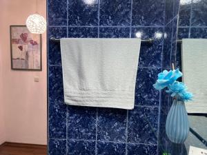 Baño con una toalla colgada en una pared de azulejos azules en Къща за гости Шарон en Petrich