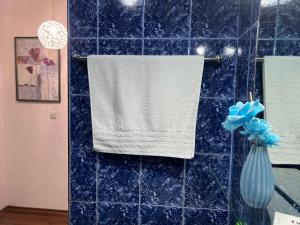 a bathroom with a towel hanging on a blue tiled wall at Къща за гости Шарон in Petrich +20 photos