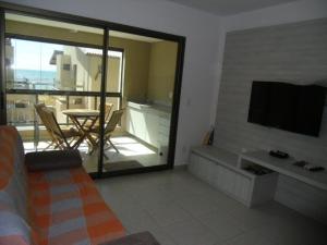 a living room with a flat screen tv on a wall at Beira Mar Muro Alto no Condomínio Ekoara ap 202 in Porto De Galinhas