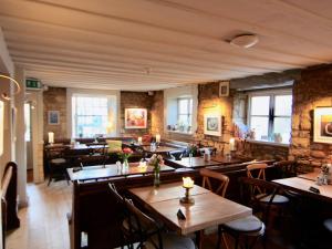 um restaurante com mesas e cadeiras num quarto em The Mousetrap Inn em Bourton on the Water