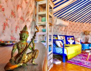 a living room with a doll playing a guitar at Exclusive Nirvana yurts Glamping in Kato Drys