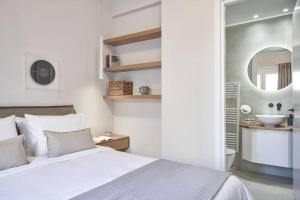 a white bedroom with a bed and a sink at Sleeping with the Ancient Gods in Koukaki in Athens