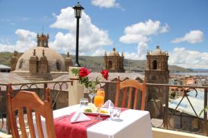 a table on a balcony with a view of a city at Conde de Lemos Hotel in Puno