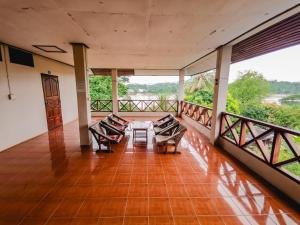 a room with a table and chairs on a balcony at Sabaydee Guesthouse in Ban Houayxay