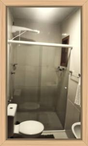 ein Badezimmer mit Glasdusche und Toilette in der Unterkunft RESIDENCIAL RECANTO Do THEOZINHO in Bombinhas