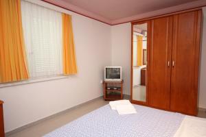 ein Schlafzimmer mit einem Bett und einem Fernseher in der Unterkunft Apartment Slano 3183c in Slano