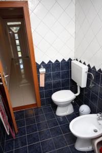 ein blau gefliestes Badezimmer mit Toilette und Waschbecken in der Unterkunft Apartment Slano 3183c in Slano