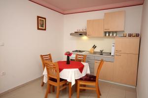 eine Küche mit Tisch und Stühlen und einem Kühlschrank in der Unterkunft Apartment Slano 3183c in Slano + 17 Fotos