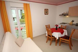 eine Küche und ein Esszimmer mit Tisch und Stühlen in der Unterkunft Apartment Slano 3183c in Slano