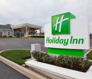 a sign for a holiday inn in front of a parking lot at Holiday Inn Redding by IHG in Redding