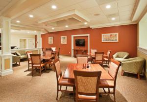 Holiday Inn Redding, an IHG Hotel في ريدينغ: مطعم بطاولات وكراسي خشبية وتلفزيون بشاشة مسطحة