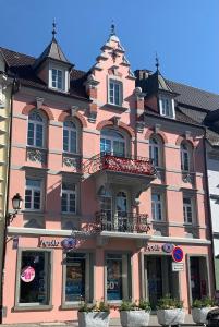 um grande edifício cor-de-rosa com uma varanda em Ferienwohnung MaRe em Stockach