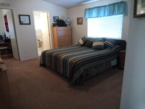 a bedroom with a bed and a window at Kokopelli Kottage in Kanab