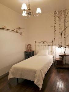 a bedroom with a white bed and trees on the wall at Casa San Pablo in Melide