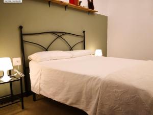 a bedroom with a white bed with a black headboard at Casa San Pablo in Melide