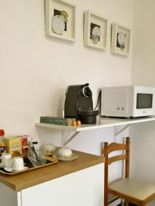 a kitchen counter with a microwave and a table at Apartamento con jardín y terraza Casa San Pablo in Melide