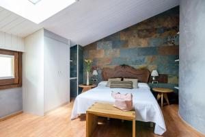 a bedroom with a bed and a stone wall at Hotel Els Caçadors de Ribes in Ribes de Freser