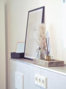 a shelf with a picture on top of a dresser at Neubau Ferienwohnung Winterscheid nahe zu Köln Bonn bis 4 Personen mit Netflix und mehr in Ruppichteroth