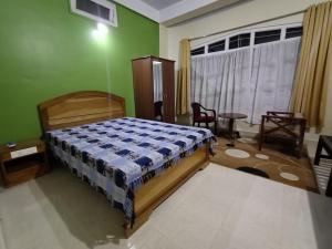Jowai的住宿－Odyssey Stays Jowai - West Jaintia Hills，一间卧室设有一张床和绿色的墙壁