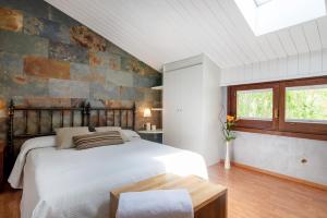 a bedroom with a bed and a brick wall at Hotel Els Caçadors de Ribes in Ribes de Freser