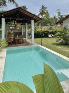 a swimming pool in a backyard with a pavilion at Kanferri Villa in Ahangama