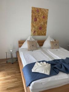 two twin beds in a room with a painting on the wall at Quality See Apartments Reifnitz in Reifnitz