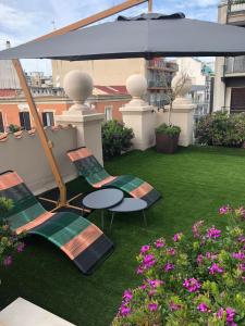 un patio con 2 sillas, una mesa y una sombrilla en PALAZZO DANISI ROOMS&SUITES en Bari