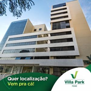 un bâtiment dans le parc de la villa avec un logo vert dans l'établissement Villa Park Hotel, à Natal