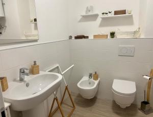 a white bathroom with a sink and a toilet at Casa Doris in Oggebbio