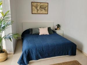 1 dormitorio con 1 cama con manta azul en CASA DEL MAR - Cozy Beach House, en El Médano