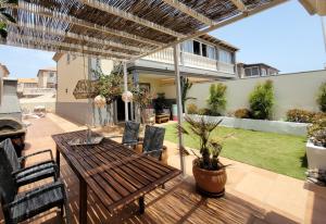 un patio al aire libre con mesa de madera y sillas en CASA DEL MAR - Cozy Beach House, en El Médano