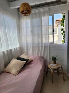 1 dormitorio con cama y ventana en CASA DEL MAR - Cozy Beach House, en El Médano