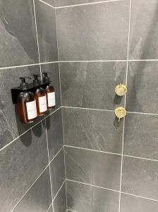 dos botellas de aceites esenciales se sientan en una ducha de azulejos en Hygge at Vallum en Newcastle