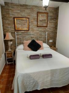 una camera da letto con un letto con due cuscini sopra di Casa Pepa ad Algar