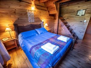 1 dormitorio con 1 cama en una cabaña de madera en Hosteria Pichi Rincon en Villa La Angostura