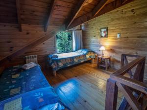 um quarto com duas camas num chalé de madeira em Hosteria Pichi Rincon em Villa La Angostura