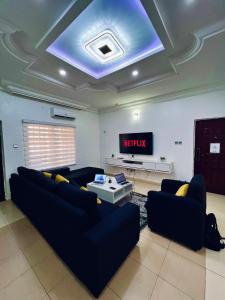 sala de estar con sofá y TV en The Blcksite: A 3 bedroom apartment in Wuse, en Abuja