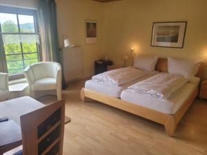 a bedroom with a large bed and a chair at Weingut Raevenhof in Ayl