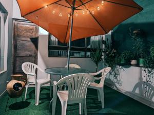 einen Tisch mit Stühlen und einen Regenschirm in einem Zimmer in der Unterkunft Samayuna Wasi , entire apartment Cusco in Cusco