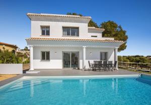 a villa with a swimming pool in front of a house at Villa Vallesa Calpe in Ifach