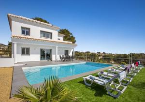 eine Villa mit einem Pool und Liegestühlen in der Unterkunft Villa Vallesa Calpe in Calpe