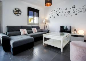 ein Wohnzimmer mit einem Sofa und einem Tisch in der Unterkunft Villa Vallesa Calpe in Calpe